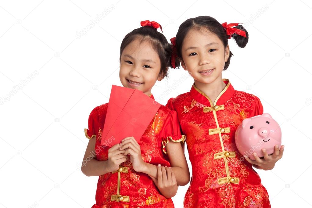 Asian twins girls in  chinese cheongsam dress with coin bank and