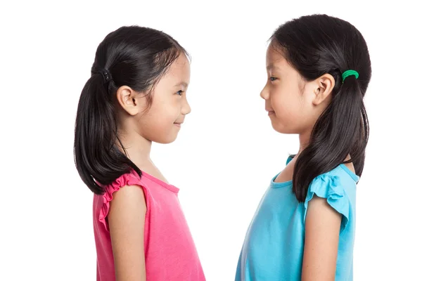 Счастливые азиатские близнецы девушки улыбаются смотреть друг на друга — стоковое фото