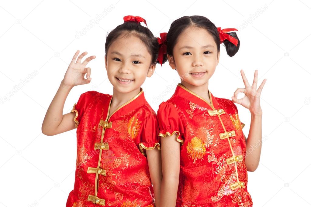 Asian twins girls in  chinese cheongsam dress show OK sign