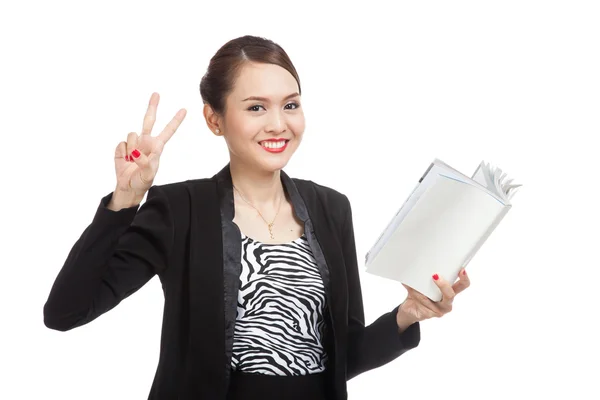 Young Asian business woman show victor sign with a book — Stock Photo, Image