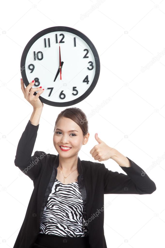 Young Asian business woman thumbs up with a clock