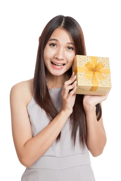 Excited beautiful young Asian woman with golden gift box — Stock Photo, Image