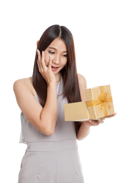 Excited beautiful young Asian woman with golden gift box — Stock Photo, Image