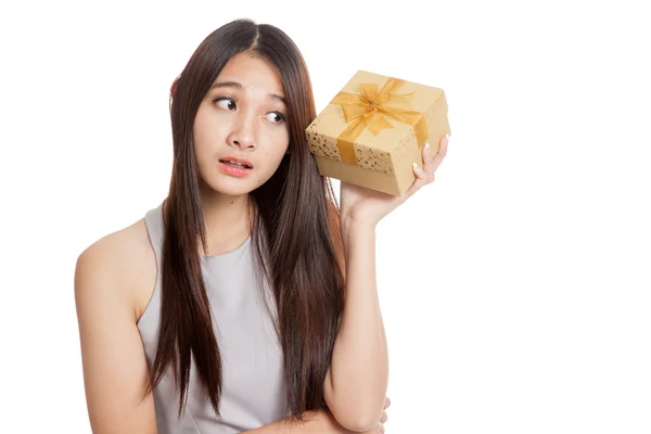Красивая молодая азиатка интересуется что в золотой коробке подарка — стоковое фото