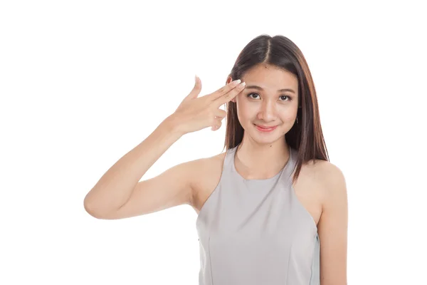 Schöne junge asiatische Frau hält die Finger in Waffe Geste — Stockfoto