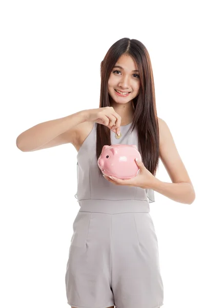 Mooie jonge Aziatische vrouw met piggy bank en munten — Stockfoto