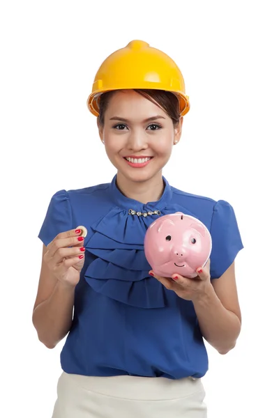 Asian engineer woman with a coin and piggy coin bank — Stock Photo, Image
