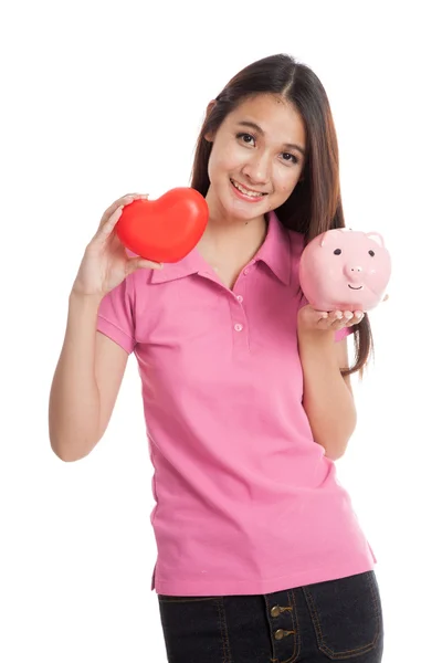 Beautiful Asian girl with red heart and piggy bank — Stock Photo, Image