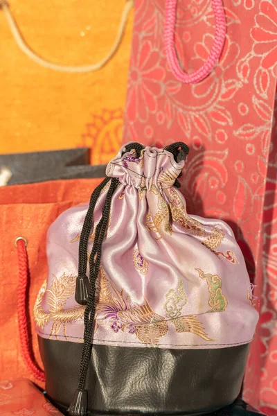 Colorful paper carry bags and a silk cloth pouch