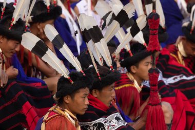 Selective focus image of Naga tribesmen wearing their traditional attire and siting together in Kisama heritage Village arena in Nagaland India on 4 December 2016
