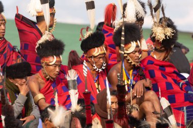 4 Aralık 2016 'da Hindistan' ın Nagaland kentindeki Kisama Köyü arenasında geleneksel kıyafetlerini giymiş ve birlikte oturan Naga kabilesinin seçici odak noktası.