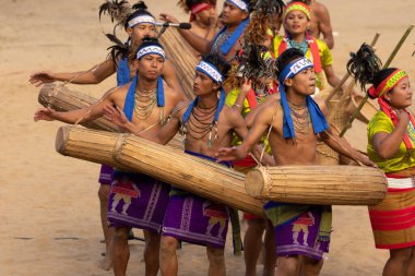 3 Aralık 2016 'da Kisama köyü Nagaland Hindistan' da Hornbill festivali sırasında geleneksel müzik enstrümanlarını çalıp dans eden bir grup genç Naga kabilesinin seçici odak noktası.