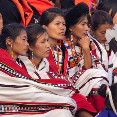 Nagaland Hindistan 'daki Kisama Heritage köyünde 3 Aralık 2016' da renkli kıyafetler ve şallar giyen genç Naga kabile kadınlarının seçici odak noktası.