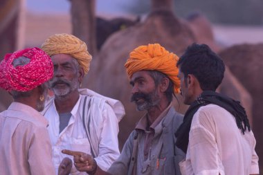 18 Kasım 2018 'de Pushkar, Rajasthan, Hindistan' da türban takan ve birbirleriyle konuşan bir grup adam.