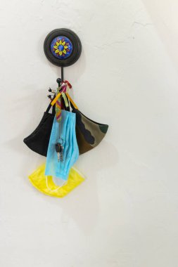 Duvarda bir sürü anahtarla asılı çeşit çeşit yüz maskeleri.