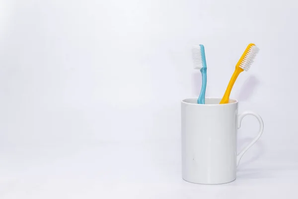 Pair Colourful Tooth Brusher Kept Withe Cup White Copy Space — Stock Photo, Image