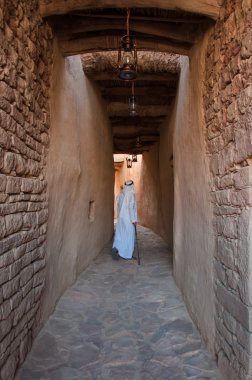 Saudian walking inside the walls of Al-Ula Old City, Saudi Arabi clipart
