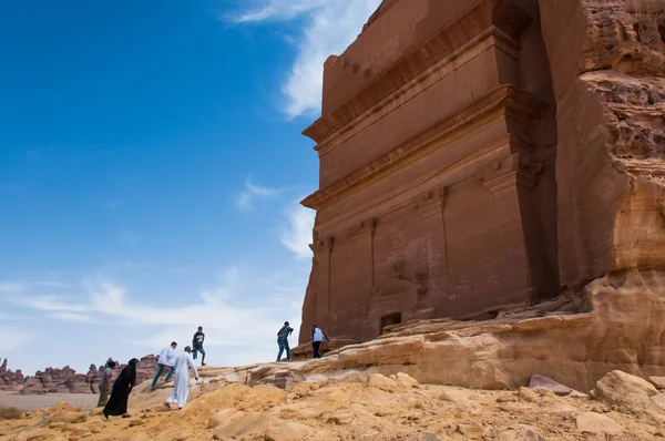 People entering a Nabatean tomb in Madaîn Saleh archeological s — стокове фото