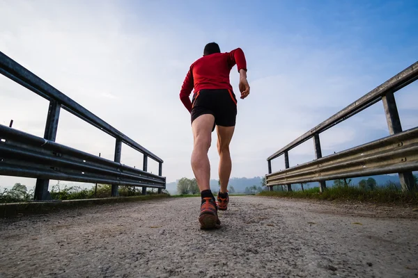 Un uomo che corre in campagna la mattina presto — Foto Stock