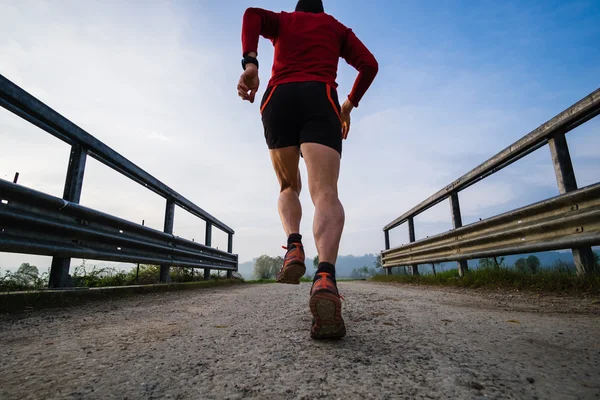 Un uomo che corre in campagna la mattina presto — Foto Stock