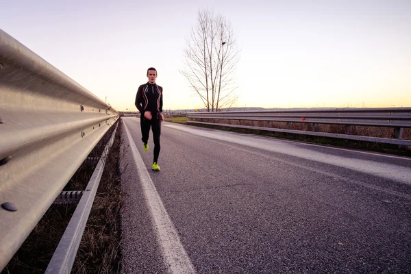 A young man running on the road — Stock Photo, Image