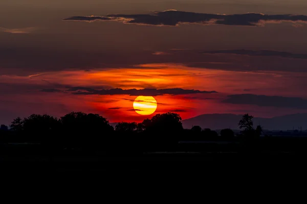 Red sunset bhind the clouds — Stock Photo, Image