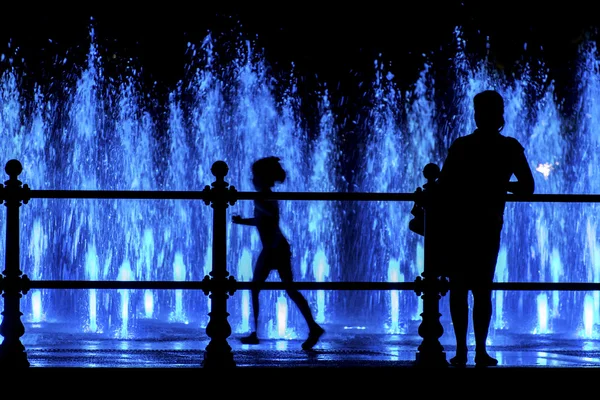 Moeder en kind te kijken naar een kleurrijke fontein — Stockfoto