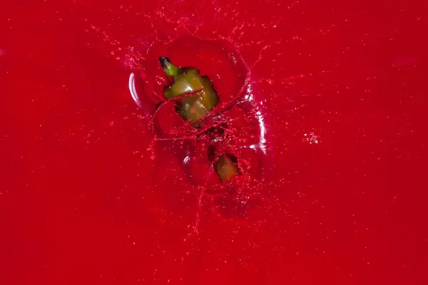 Green hote pepper in red water — Stock Photo, Image