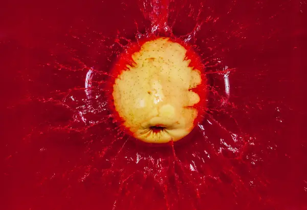 Κίτρινο μήλο στο κόκκινο νερό — Φωτογραφία Αρχείου