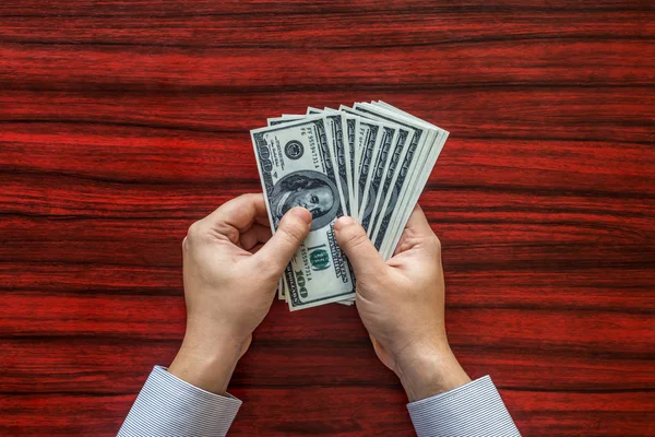 Tellen van geld op een bureau — Stockfoto