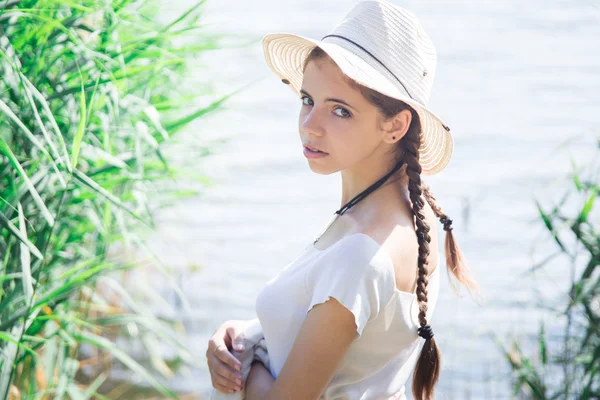 Beautiful girl in a straw hat on the lake — Stock Photo, Image