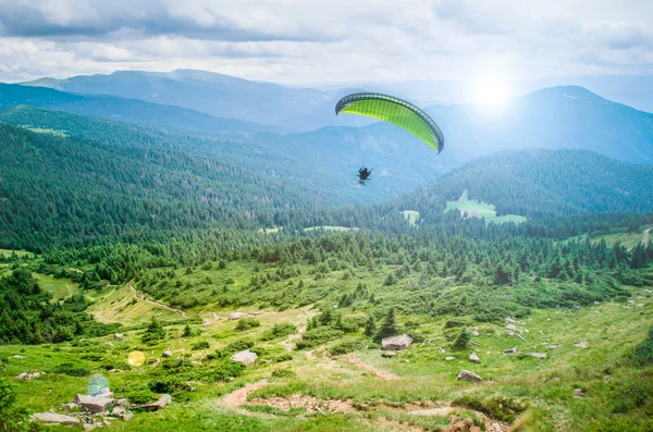 Silhouette parapendio sulle cime delle montagne . Immagine Stock