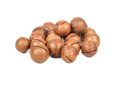 Beyaz arka planda kabuklu macadamia fındığı yığını.