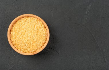 Boş beton arka planda kahverengi şekerli ahşap kase, üst manzara.