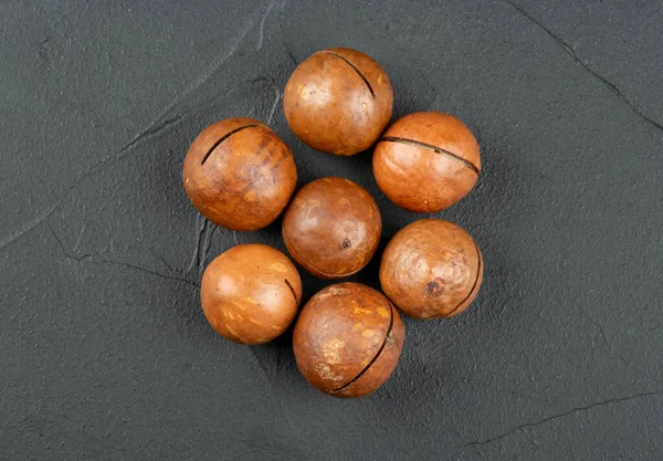Несколько Орехов Макадамии Темном Бетонном Фоне Вид Сверху — стоковое фото