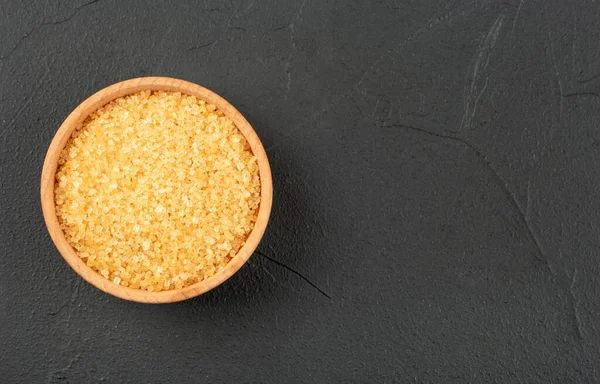 Boş beton arka planda kahverengi şekerli ahşap kase, üst manzara.