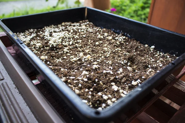 Kahverengi toprak ve gübre ile büyük bir kare pot 