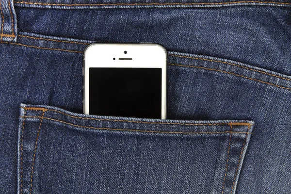Parte do celular branco móvel no bolso traseiro da ganga azul — Fotografia de Stock