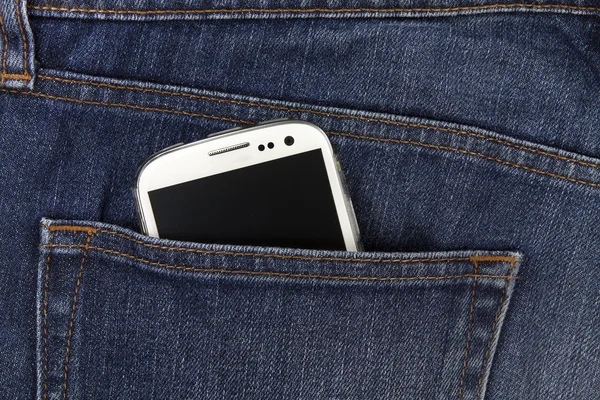 Part of mobile white cellphone in the back pocket of blue denim — Stock Photo, Image