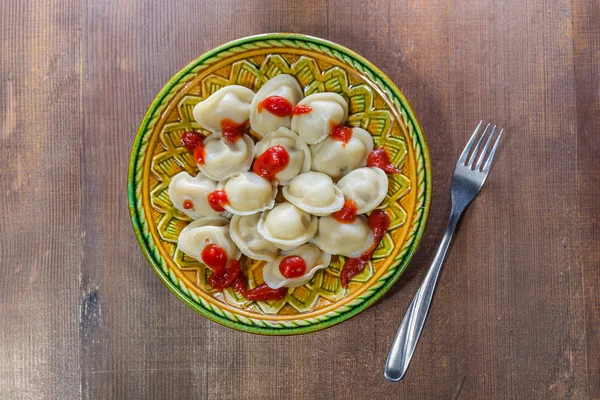 Ketchup pelmeni pe o masă întunecată — Fotografie, imagine de stoc