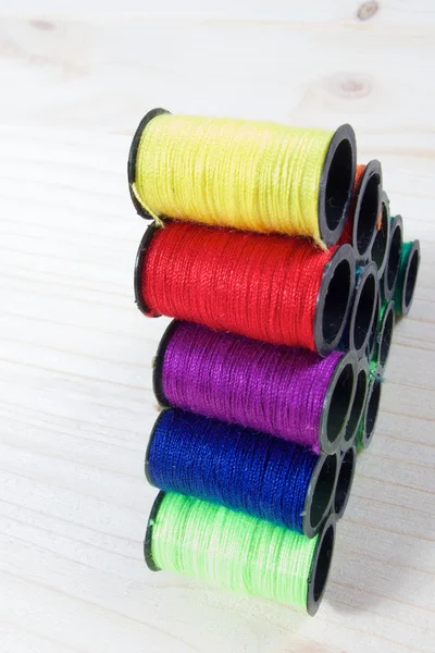 Arco-íris de carretéis de fios coloridos na mesa — Fotografia de Stock