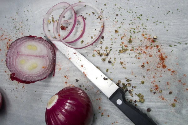 Red onion rings on baking paper with spices — Stock Photo, Image