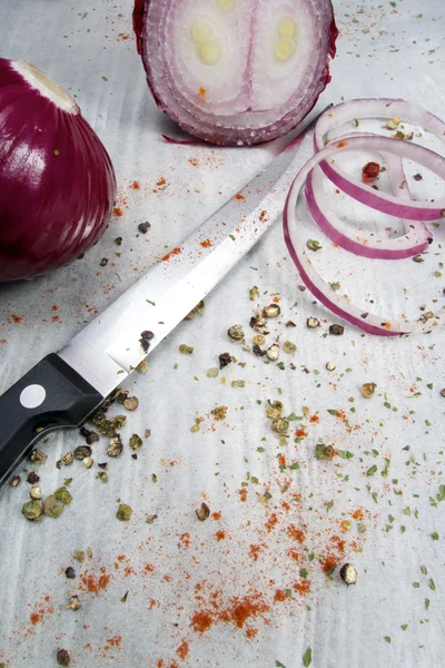 Red onion rings on baking paper with spices — Stock Photo, Image