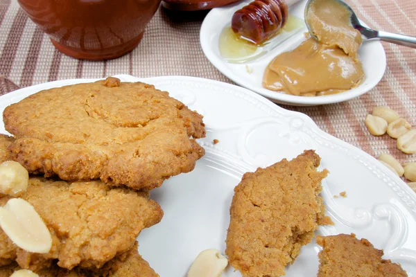 Sweet healthy peanut cookies on wooden table with honey — Stock Photo, Image