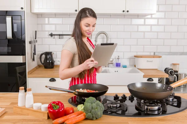 Mujer atractiva con la tableta en la cocina . —  Fotos de Stock