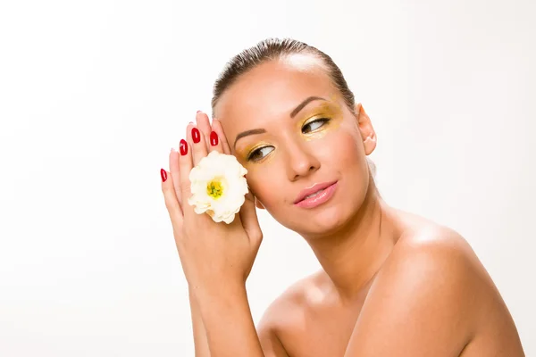 Zlaté make-upu. Hnědá elegantní vlasy krásná žena s bílým květem — Stock fotografie