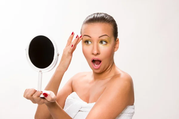 Altın makyaj. Kahverengi şık saç aynaya bakıyor güzel kadın