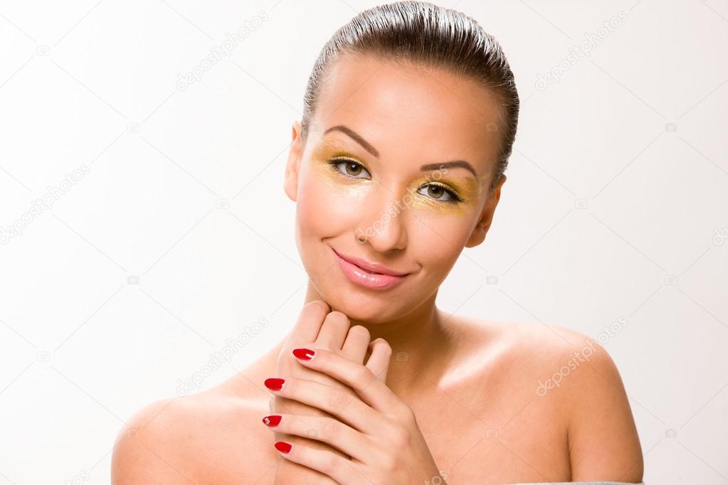 Brown sleek hair beautiful woman with hands close to face.