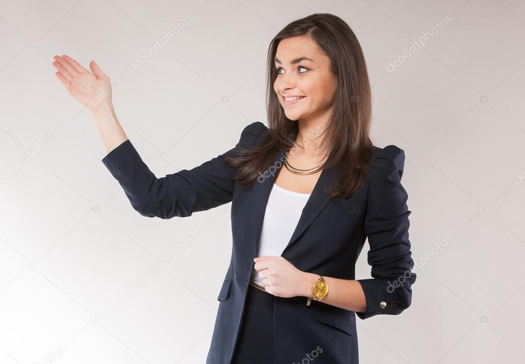 Young attractive businesswoman holding hand up