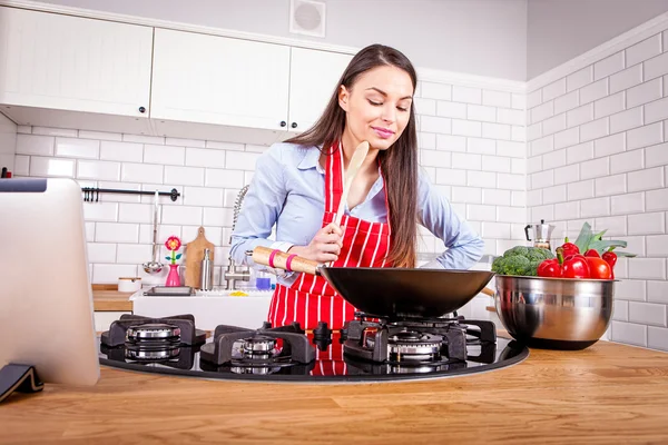 Mladá žena vaření v kuchyni. — Stock fotografie